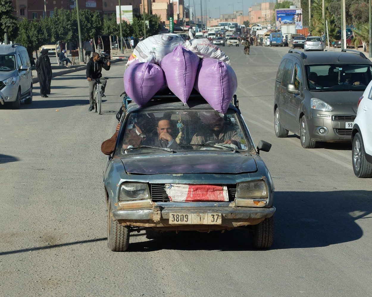 Foto en color de un choche muy cargado y viejo en una carretera de marruecos. Venta online