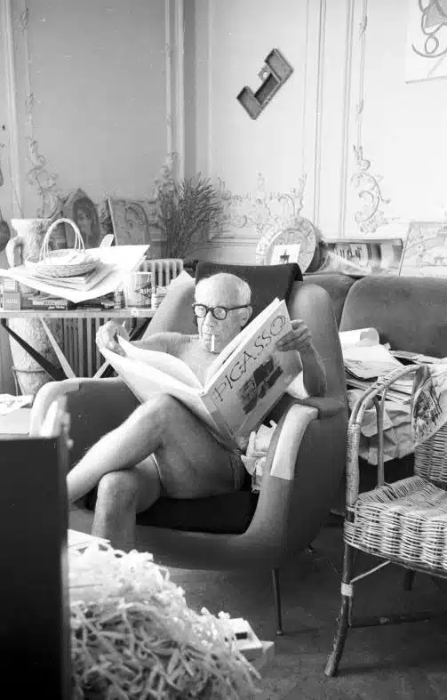 Pablo Picasso leyendo un libro sobre él mismo con gafas muy gordas estilo "bartolo"· Fotografía antigua en blanco y negro.