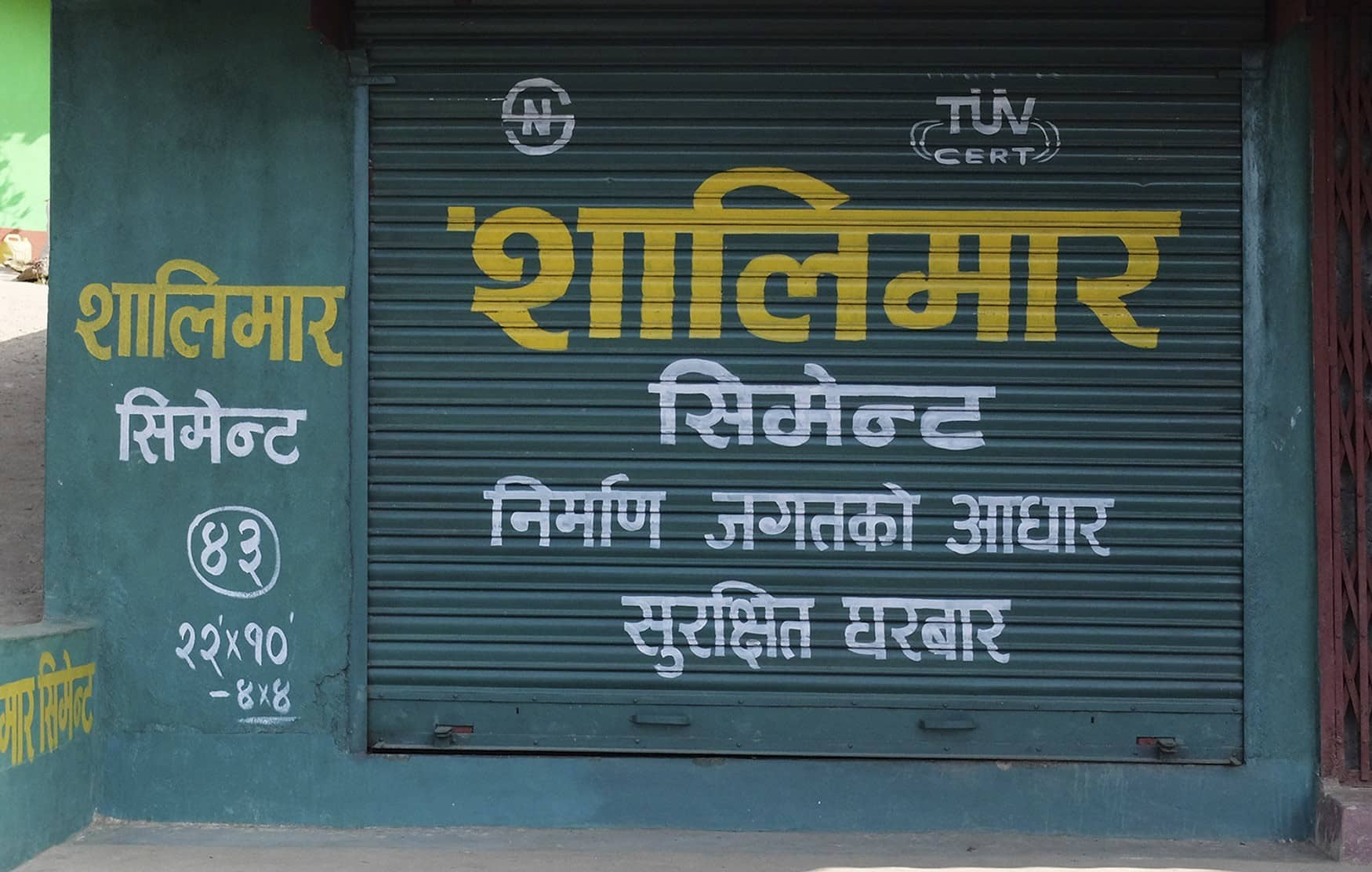 Fotografía en color de un graffiti con un diseño gráfico espectacular. Puerta de un negocio en Ilam, Nepal. Arte