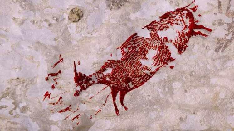 Fotografía de una pintura rupestre que representa una vaca o bufalo en la isla de Celebes en Indonesia