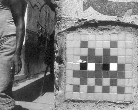 Fotografía en blanco y negro de un mosaico de Space Invaders en Varanasi, India